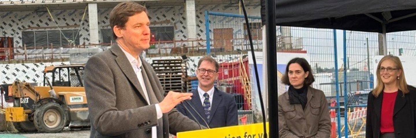 Premier David Eby stands at a podium during a media announcement